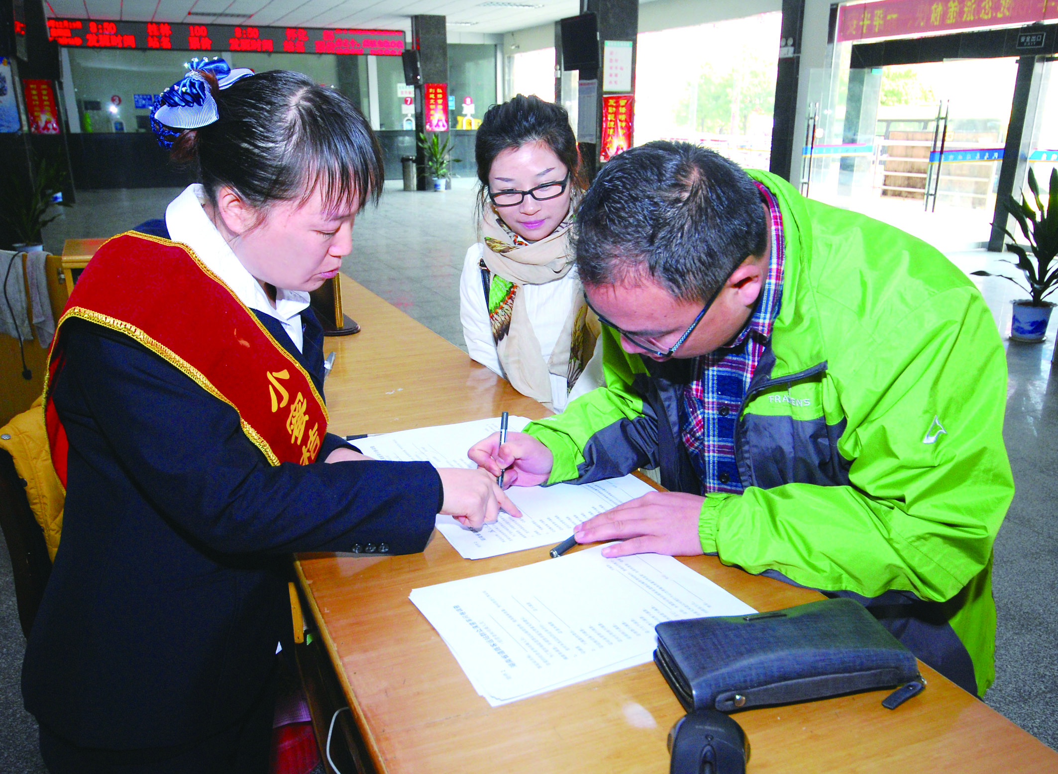 圖為洞口汽車總站站務人員在熱心為旅客服務。