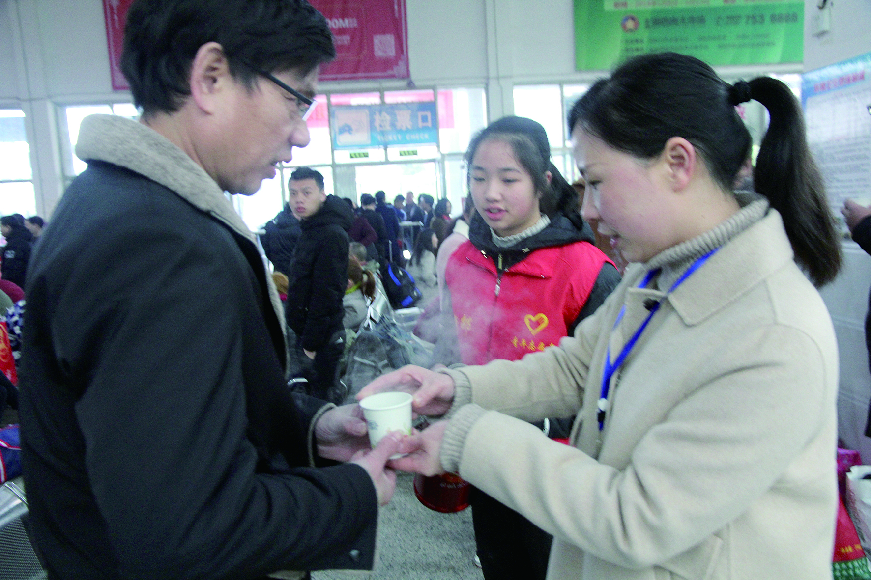 母女服務(wù)春運 2月13日，記者在新邵分公司汽車站看到，該分公司安全科副科長李喜梅與其在新邵一中初中部1701班就讀女兒劉嘉怡在車站擔(dān)當(dāng)志愿者。李喜梅在候車室耐心為旅客釋疑解惑，劉嘉怡為旅客遞上一杯杯熱茶，有時母女也相互合作，其樂融融。 祖冠 攝影報道